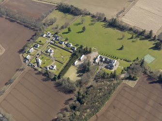 Oblique aerial view centred on the country house, its policies and the modern housing development, taken from the NW.