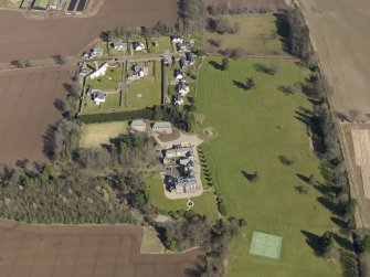 Oblique aerial view centred on the country house, its policies and the modern housing development, taken from the WSW.