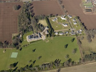 Oblique aerial view centred on the country house, its policies and the modern housing development, taken from the SSE.