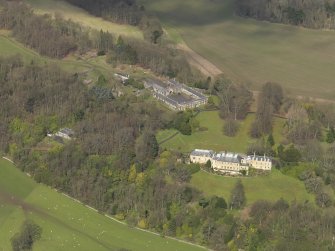 Oblique aerial view centred on the house with the stable block adjacent, taken from the SE.