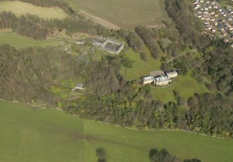 General oblique aerial view centred on the house with the stable block adjacent, taken from the S.