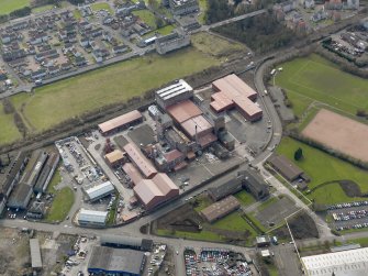 Oblique aerial view centred on the Nairn's North linoleum works with the steel works adjacent, taken from the NE.