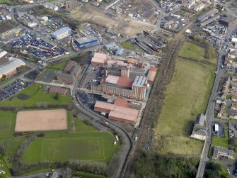 Oblique aerial view centred on the Nairn's North linoleum works with the steel works adjacent, taken from the SW.