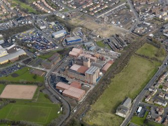 Oblique aerial view centred on the Nairn's North linoleum works with the steel works adjacent, taken from the SSW.