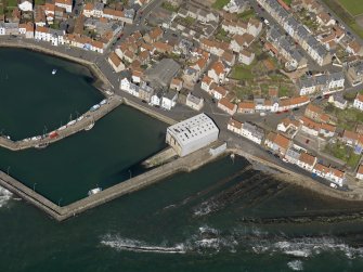 Oblique aerial view centred on the boathouse/boatshed with the harbour adjacent, taken from the SE.