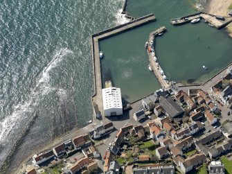 Oblique aerial view centred on the boathouse/boatshed with the harbour adjacent, taken from the NE.