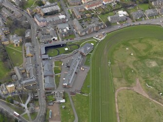 Oblique aerial view centred on the race course grandstands with the paddock adjacent, taken from the E.