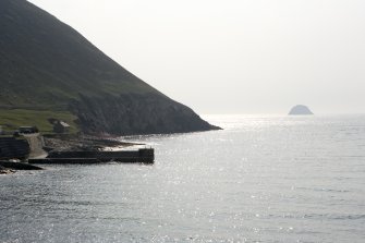 Village Bay, Quay. General view from NW with SW slope of Oiseval and Levenish in the distance.