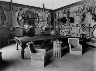 View of billiard room showing animals skins and antlered heads on walls in Montgreenan House, Ayrshire.