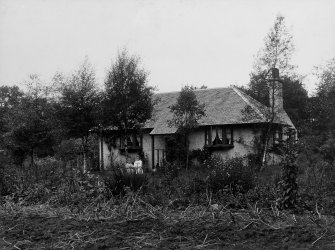 View of one storey dwelling house showing two girls.

