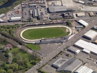 Oblique aerial view centred on the greyhound stadium, taken from the W.