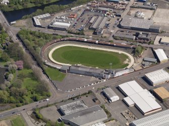 Oblique aerial view centred on the greyhound stadium, taken from the SW.