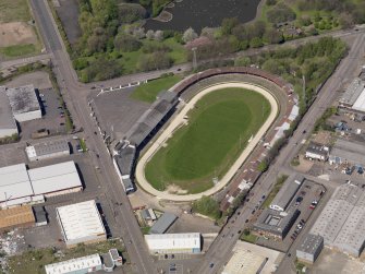 Oblique aerial view centred on the greyhound stadium, taken from the SSE.