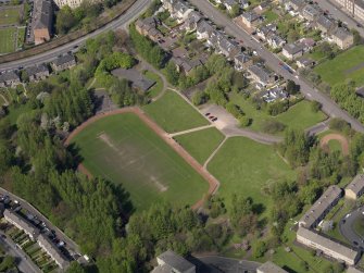 Oblique aerial view centred on the remains of the football ground, taken from the SE.