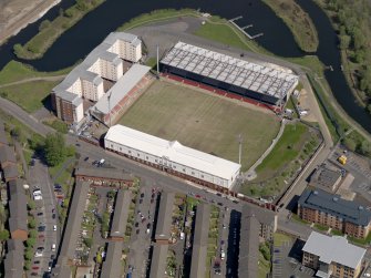 Oblique aerial view centred on the football ground with the apartment block adjacent, taken from the SW.