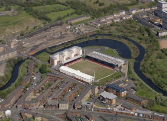 General oblique aerial view centred on the football ground with the apartment block adjacent, taken from the SW.