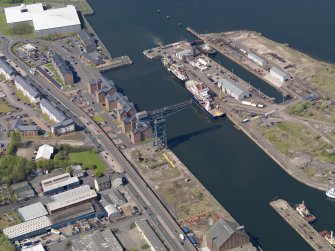 Oblique aerial view centred on the dock, taken from the SE.