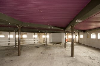 Interior. Second floor. West end. Section A.  Looking towards lift. Note the cast iron columns and wooden,  plaster-covered ceiling joists.