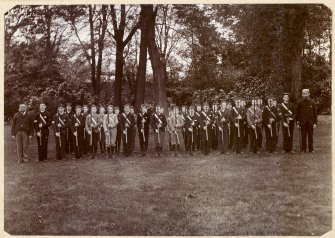 Group portrait of parade of boys holding rifles possibly in the grounds of Kinnaird House,