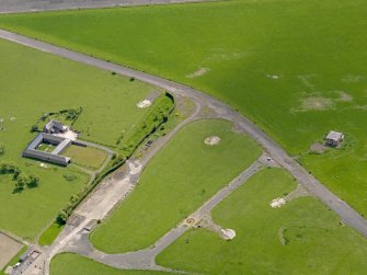 Oblique aerial view centred on the dispersal area with the control tower and farmsteading adjacent, taken from the N.