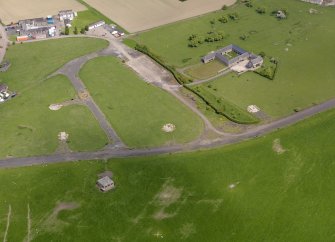 Oblique aerial view centred on the control tower with the dispersal area and farmsteading adjacent, taken from the WNW.