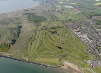 General oblique aerial view centred on the golf course with the firing range adjacent, taken from the E.