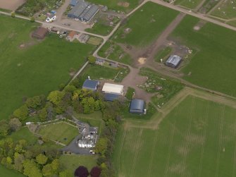 Oblique aerial view centred on the aircraft hangars with Hatton House adjacent, taken from the SSW.