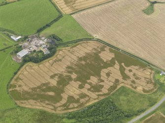 Oblique aerial view of the cropmarks of the pit defined avenue and cursus and the barrow at Kirkmabreck, taken from the ESE.