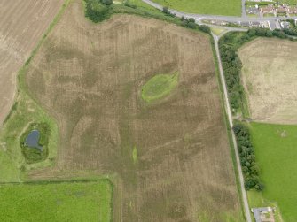 Oblique aerial view of the cropmarks of the palisaded settlements, possible enclosure and the remains of the motte at Balgreggan, taken from the W.