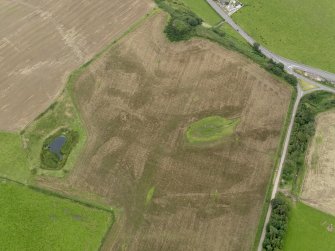 Oblique aerial view of the cropmarks of the palisaded settlements, possible enclosure and the remains of the motte at Balgreggan, taken from the WSW.