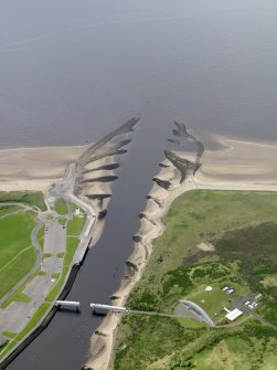 Oblique aerial view centred on the footbridge and breakwaters with the visitor centre adjacent, taken from the NE.