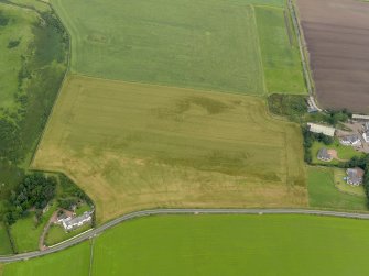 Oblique aerial view centred on the cropmarks of the rig and furrow and possible pits, taken from the S.