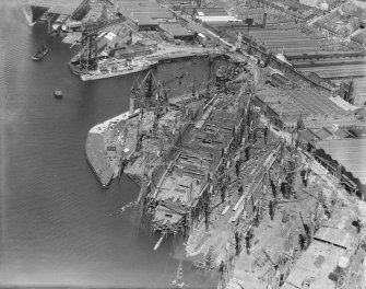 RMS Queen Elizabeth, under construction in John Brown's shipyard, Clydebank. Oblique aerial view of the liner, from S.