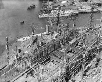 RMS Queen Elizabeth, under construction in John Brown's shipyard, Clydebank. Oblique aerial view of the liner, from E.