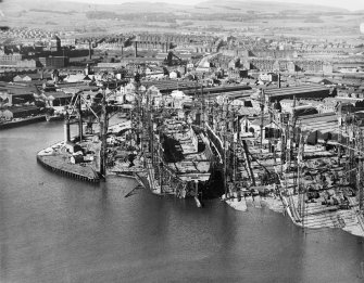 RMS Queen Elizabeth, under construction in John Brown's shipyard, Clydebank. Oblique aerial view of the liner, from S.