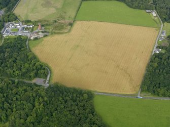 Oblique aerial view centred on the cropmarks of the barrow at Dry Bridge, Islay, taken from the SSE.