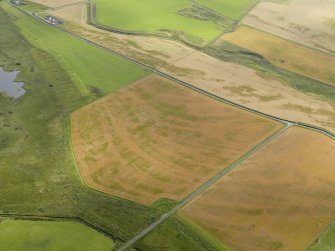Oblique aerial view of the cropmarks of the trackway, possible enclosure and pits, taken from the NW.