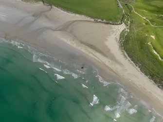 Oblique aerial view centred on the wreck of the craft on Traigh Mhachir, Islay, taken from the SW.