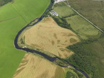 Oblique aerial view centred on the cropmarks of the enclosure and field boundaries with Island House adjacent, taken from the WSW.