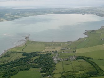 General oblique aerial view looking across Loch Ryan with the village and the remains of the sea plane base in the foreground, taken from the NNE.