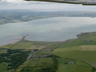 General oblique aerial view looking across Loch Ryan with the village and the remains of the sea plane base in the foreground, taken from the NW.