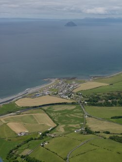 General oblique view of the village with Ailsa Craig, Arran and Kintyre in the distance and the cropmarks of the four post stone circle in the foreground, taken from the SE.