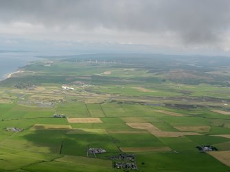 General oblique aerial view looking across Machrihanish Airfield towards the windfarm, taken from the SSW.