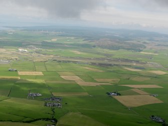 General oblique aerial view looking across Machrihanish Airfield towards the windfarm, taken from the SSE.