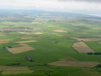 General oblique aerial view looking across Machrihanish Airfield towards the windfarm, taken from the SSE.