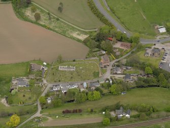 Oblique aerial view centred on the church with the graveyard adjacent, taken from the S.