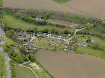 Oblique aerial view centred on the church with the graveyard adjacent, taken from the SE.