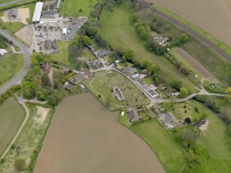 Oblique aerial view centred on the church with the graveyard adjacent, taken from the W.