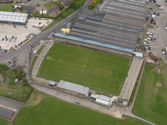 Oblique aerial view centred on the football ground with the auction mart adjacent, taken from the NNW.