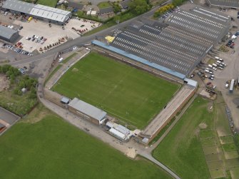 Oblique aerial view centred on the football ground with the auction mart adjacent, taken from the NW.